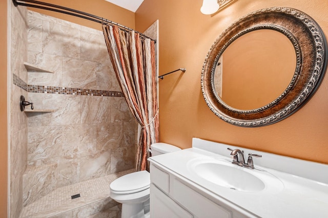 full bath featuring a tile shower, vanity, and toilet