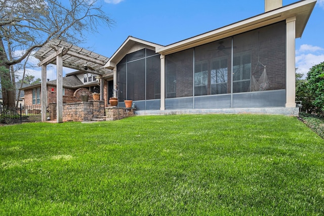 rear view of property with a sunroom, brick siding, and a lawn