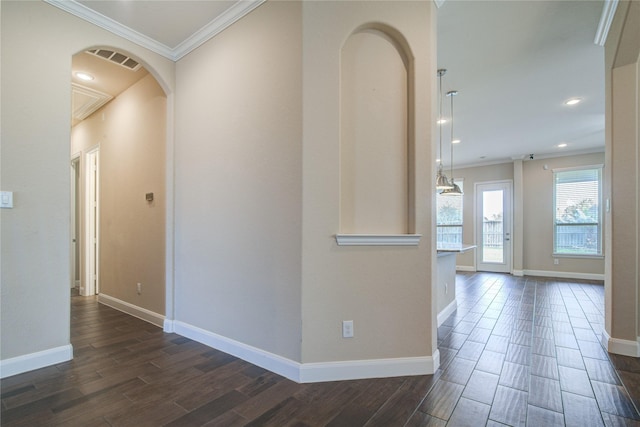 corridor with visible vents, arched walkways, crown molding, and wood finish floors