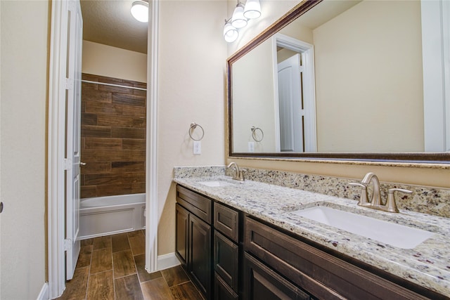 full bathroom featuring wood tiled floor, a sink, bathing tub / shower combination, and double vanity