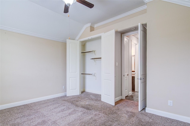 unfurnished bedroom with vaulted ceiling, baseboards, carpet flooring, and crown molding