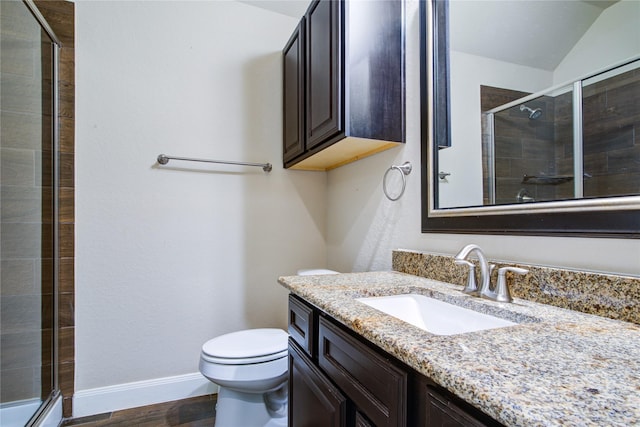 full bath featuring baseboards, toilet, wood finished floors, vanity, and a shower stall