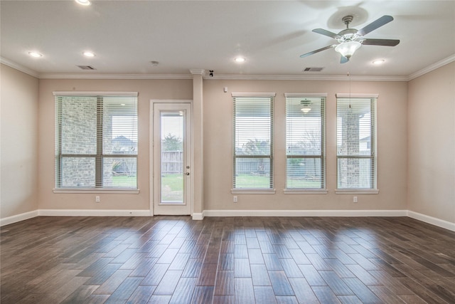 spare room with baseboards, visible vents, dark wood finished floors, and ornamental molding