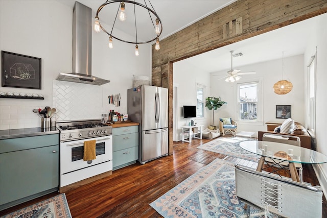 kitchen with white range with gas cooktop, visible vents, stainless steel countertops, freestanding refrigerator, and exhaust hood