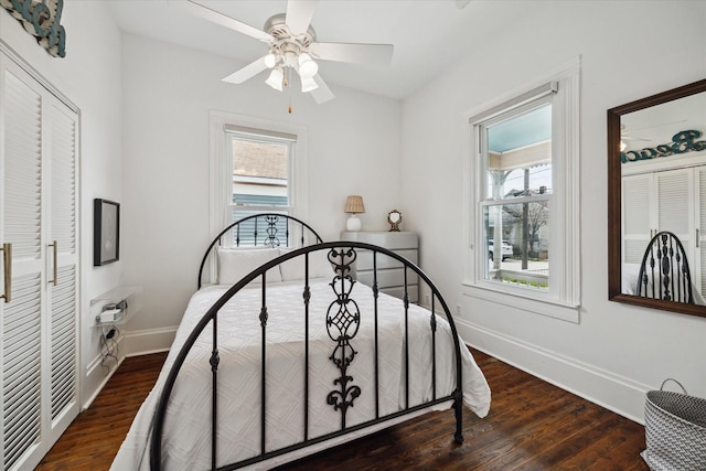 bedroom with a ceiling fan, baseboards, and wood finished floors