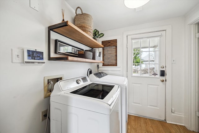 clothes washing area featuring laundry area, washer and clothes dryer, and light wood finished floors