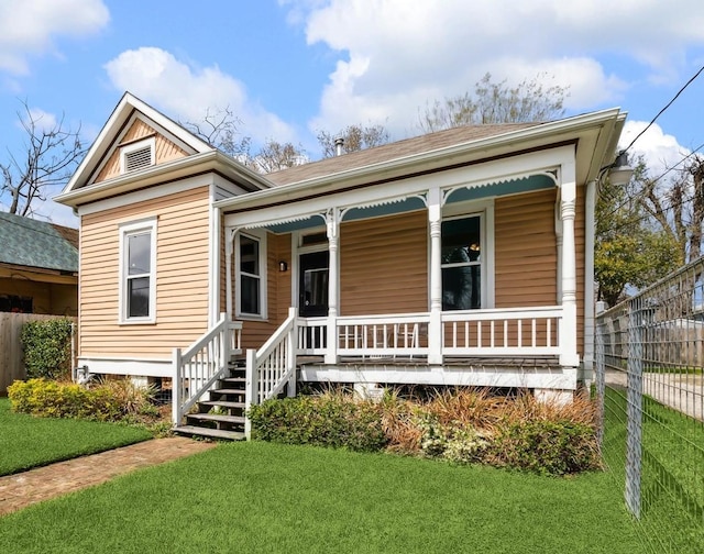 view of front of property with a porch, a front yard, and fence