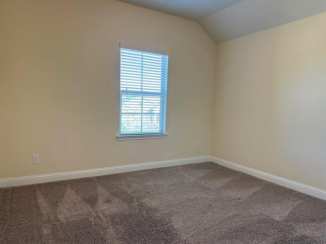 unfurnished room featuring lofted ceiling, baseboards, and carpet floors