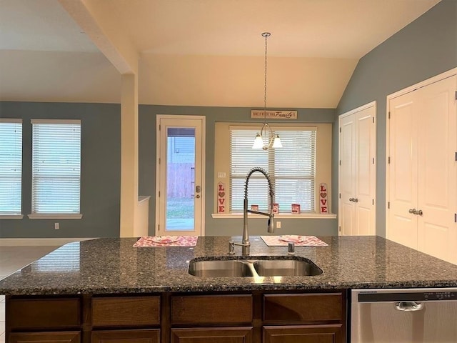 kitchen featuring dishwasher, dark stone counters, lofted ceiling, and a sink