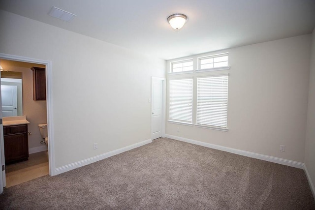 empty room featuring light colored carpet and baseboards