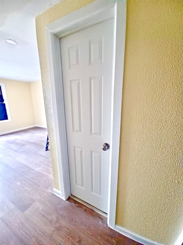 room details with a textured wall, baseboards, and wood finished floors