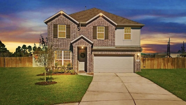 traditional home with driveway, fence, a lawn, and brick siding