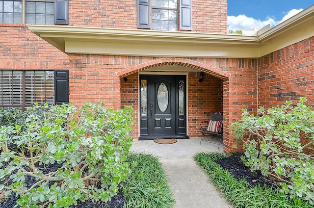 view of exterior entry featuring brick siding