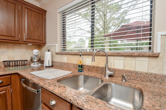 kitchen featuring brown cabinets, a sink, and backsplash