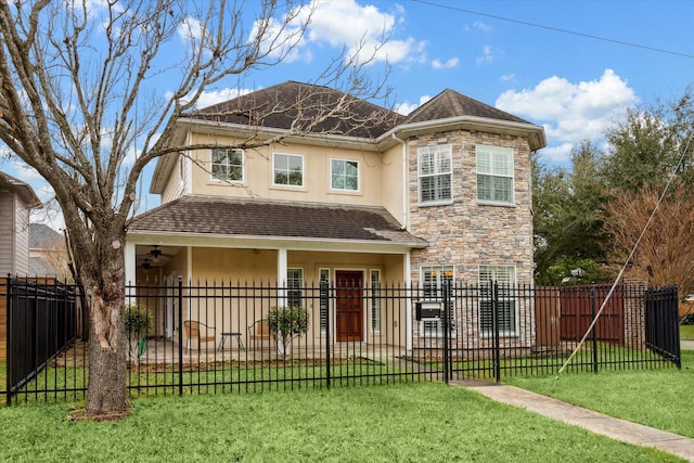 traditional home featuring a front yard, stone siding, a fenced front yard, and stucco siding