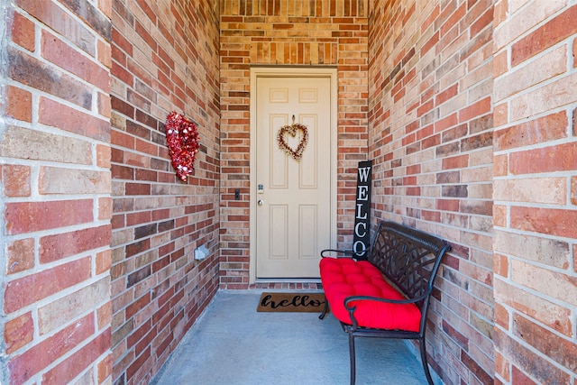 entrance to property featuring brick siding