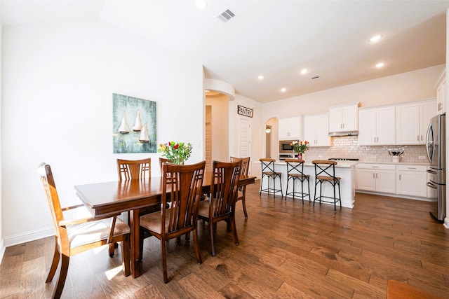 dining area featuring baseboards, visible vents, arched walkways, dark wood-type flooring, and recessed lighting