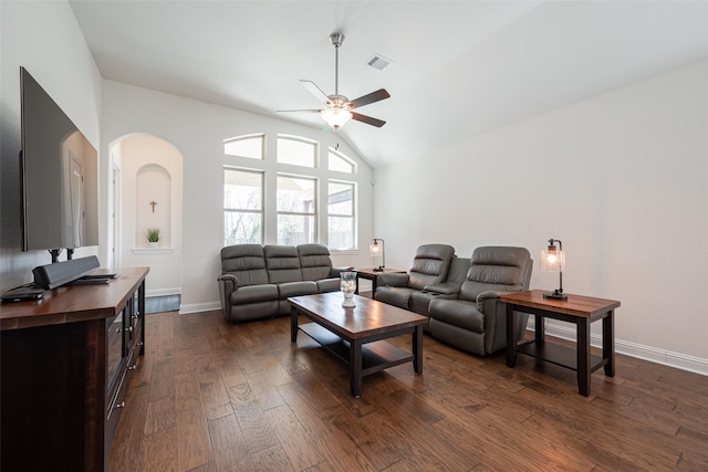 living area featuring lofted ceiling, ceiling fan, visible vents, baseboards, and dark wood finished floors