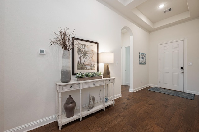 entryway with dark wood-style floors, baseboards, visible vents, and arched walkways