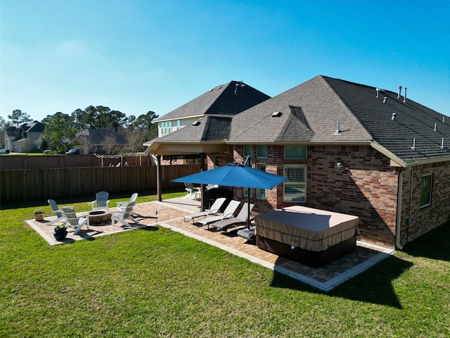 view of yard featuring a hot tub, a patio, a fire pit, and fence