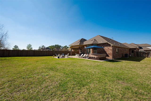 view of yard with cooling unit, a fenced backyard, a patio, and a hot tub