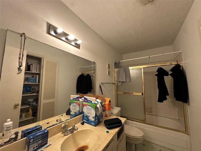 bathroom with visible vents, toilet, shower / bath combination with glass door, a textured ceiling, and vanity