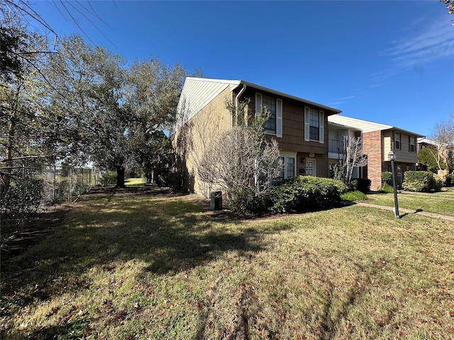 view of home's exterior with a lawn and fence