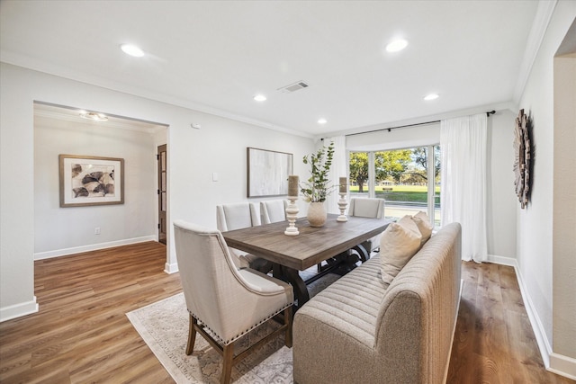 dining room with baseboards, visible vents, crown molding, light wood-type flooring, and recessed lighting