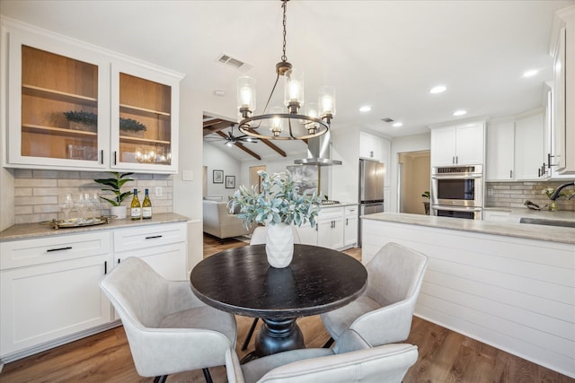 dining space with visible vents, lofted ceiling, ceiling fan, wood finished floors, and recessed lighting