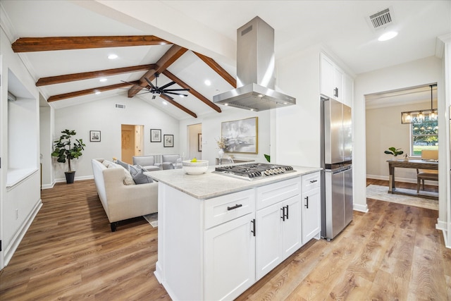 kitchen featuring island exhaust hood, visible vents, lofted ceiling with beams, appliances with stainless steel finishes, and white cabinetry