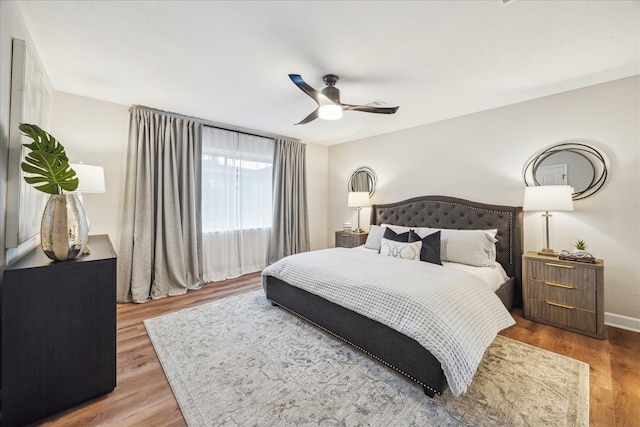 bedroom featuring ceiling fan, baseboards, and wood finished floors