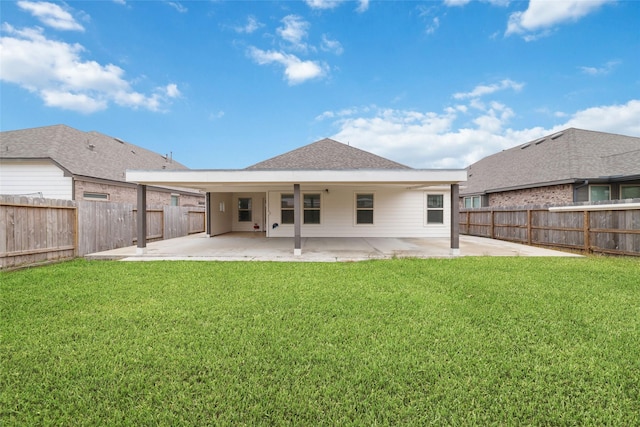 back of house with a patio area, a yard, a fenced backyard, and roof with shingles