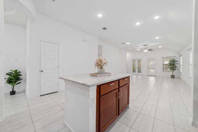 kitchen with a center island, lofted ceiling, recessed lighting, open floor plan, and light tile patterned flooring