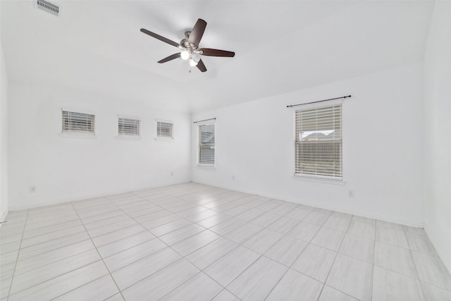 spare room featuring visible vents, ceiling fan, and baseboards