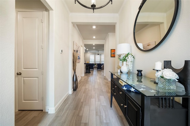 hall featuring light wood finished floors, baseboards, ornamental molding, and recessed lighting