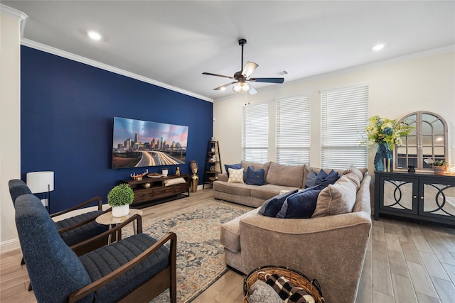 living room with light wood-type flooring, a ceiling fan, and crown molding