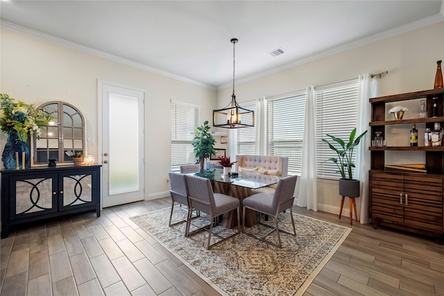 dining space with baseboards, visible vents, wood finished floors, and ornamental molding