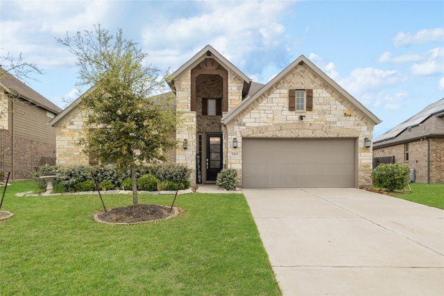 french country inspired facade featuring concrete driveway, a front lawn, an attached garage, and stone siding