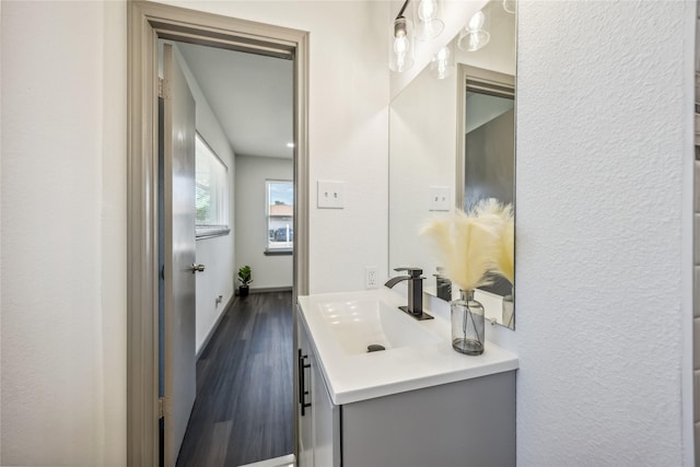 bathroom with wood finished floors, vanity, and baseboards