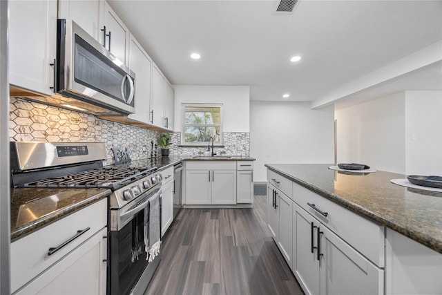 kitchen featuring white cabinetry, visible vents, stainless steel appliances, and a sink