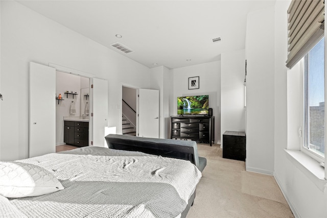 bedroom with light colored carpet, multiple windows, and visible vents