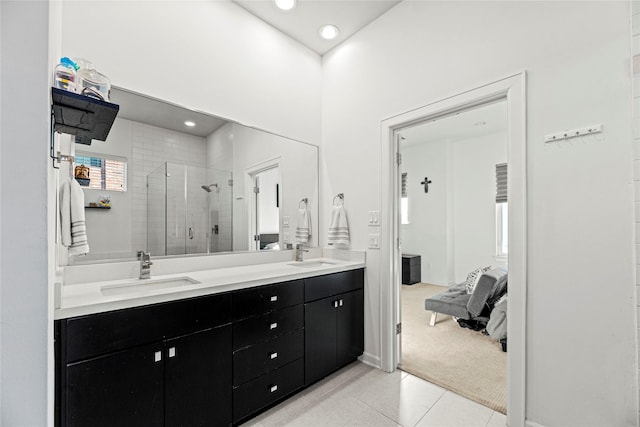 bathroom with a shower stall, tile patterned floors, double vanity, and a sink