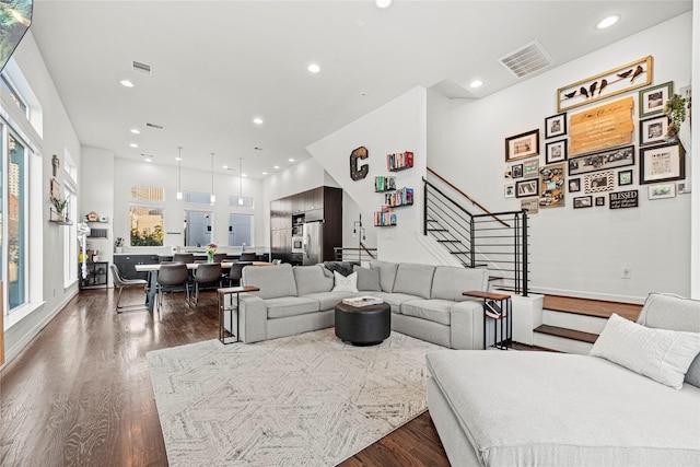 living area featuring visible vents, stairway, recessed lighting, and dark wood-style floors