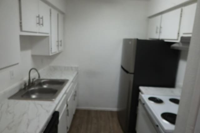 kitchen with baseboards, a sink, dark wood finished floors, and white cabinets