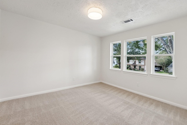 unfurnished room featuring carpet floors, visible vents, and baseboards