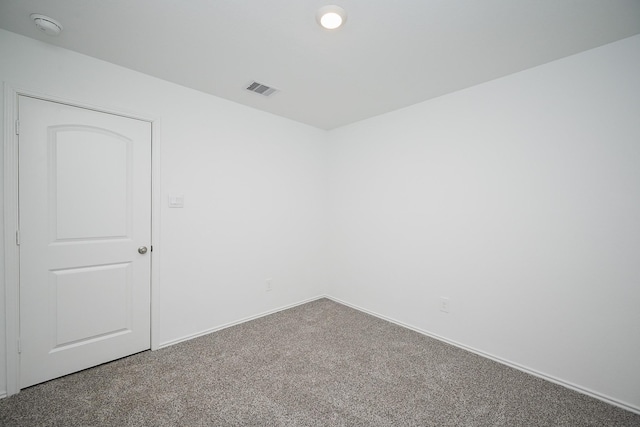 carpeted empty room featuring baseboards and visible vents