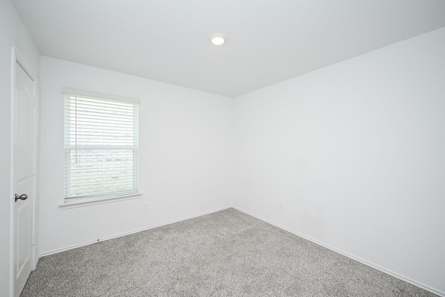 unfurnished room with carpet floors and baseboards