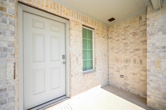 doorway to property with brick siding