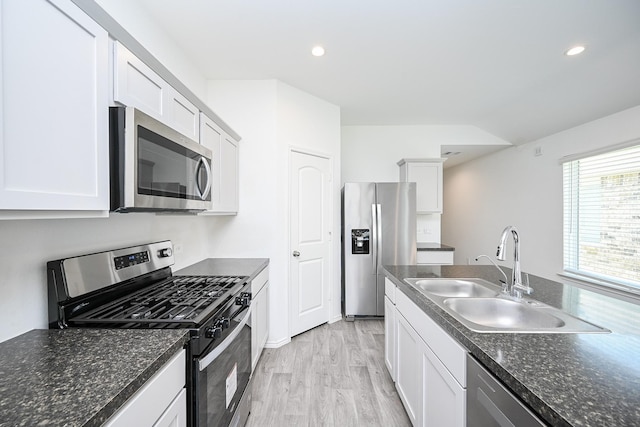 kitchen featuring recessed lighting, stainless steel appliances, a sink, white cabinets, and light wood-style floors