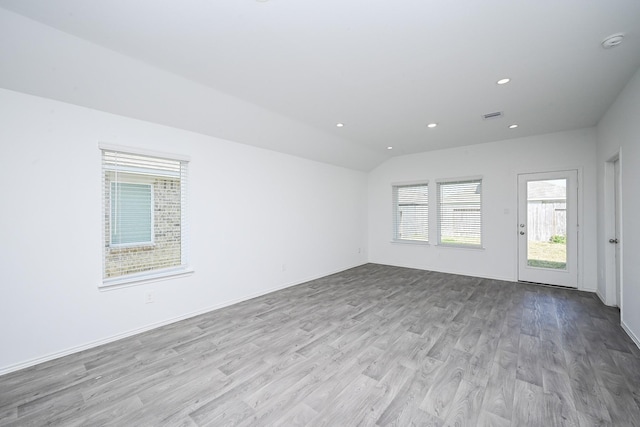 unfurnished room with baseboards, visible vents, wood finished floors, vaulted ceiling, and recessed lighting